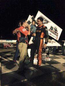 Aaron Reutzel, holding son Carson, being interviewed in victory lane after his January 10 Winter Heat triumph at Yuma's Cocopah Speedway.